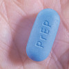 and hold blue pill with PrEP written