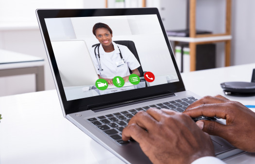Close-up Of A Person Video Conferencing With Female Doctor Through Laptop